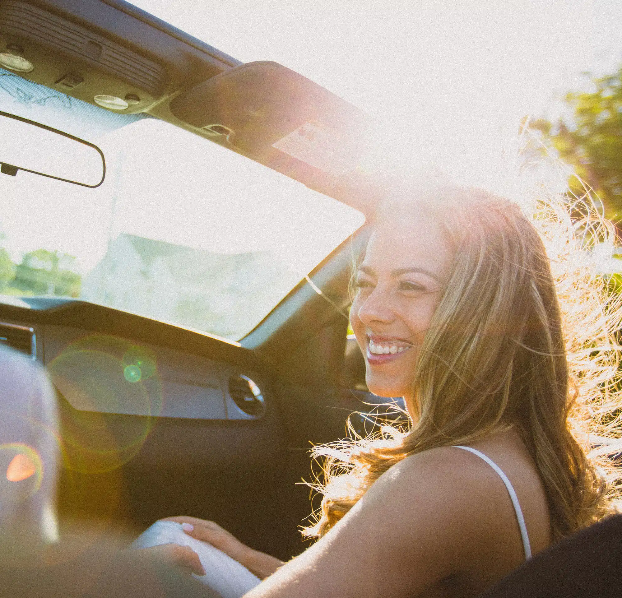 Smiling woman riding in passenger seat of a vehicle